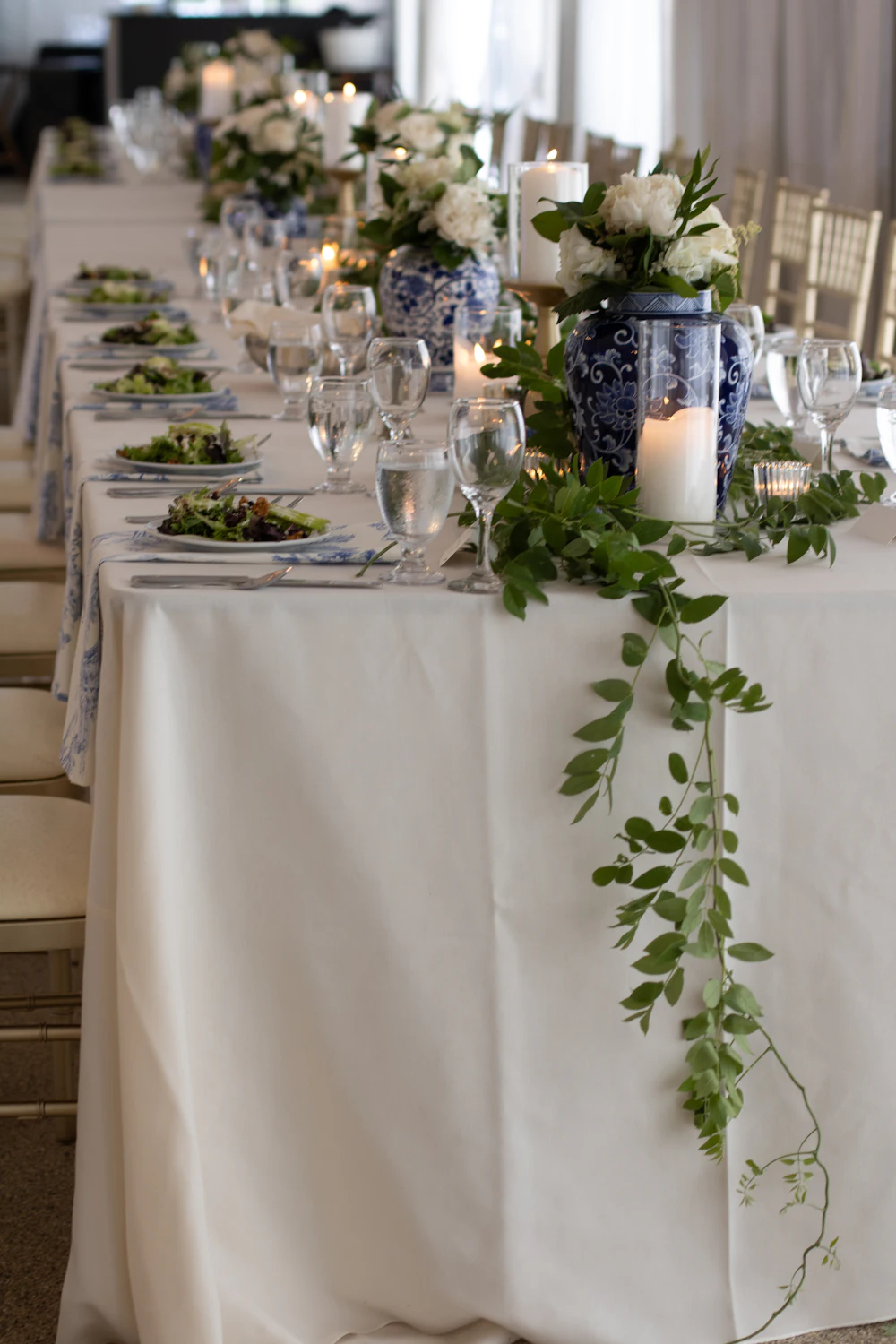 Long table dressed with flowers and greenery for a wedding reception