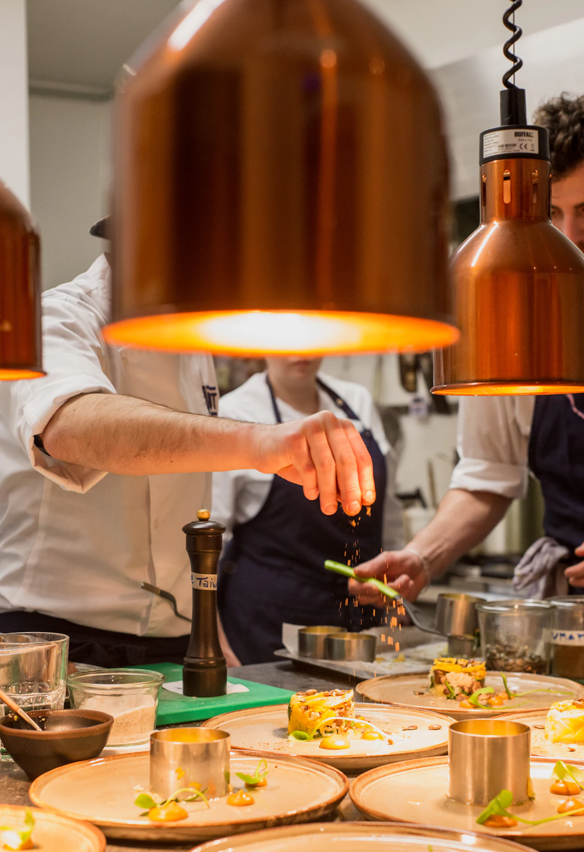 Chefs plating food in a professional kitchen