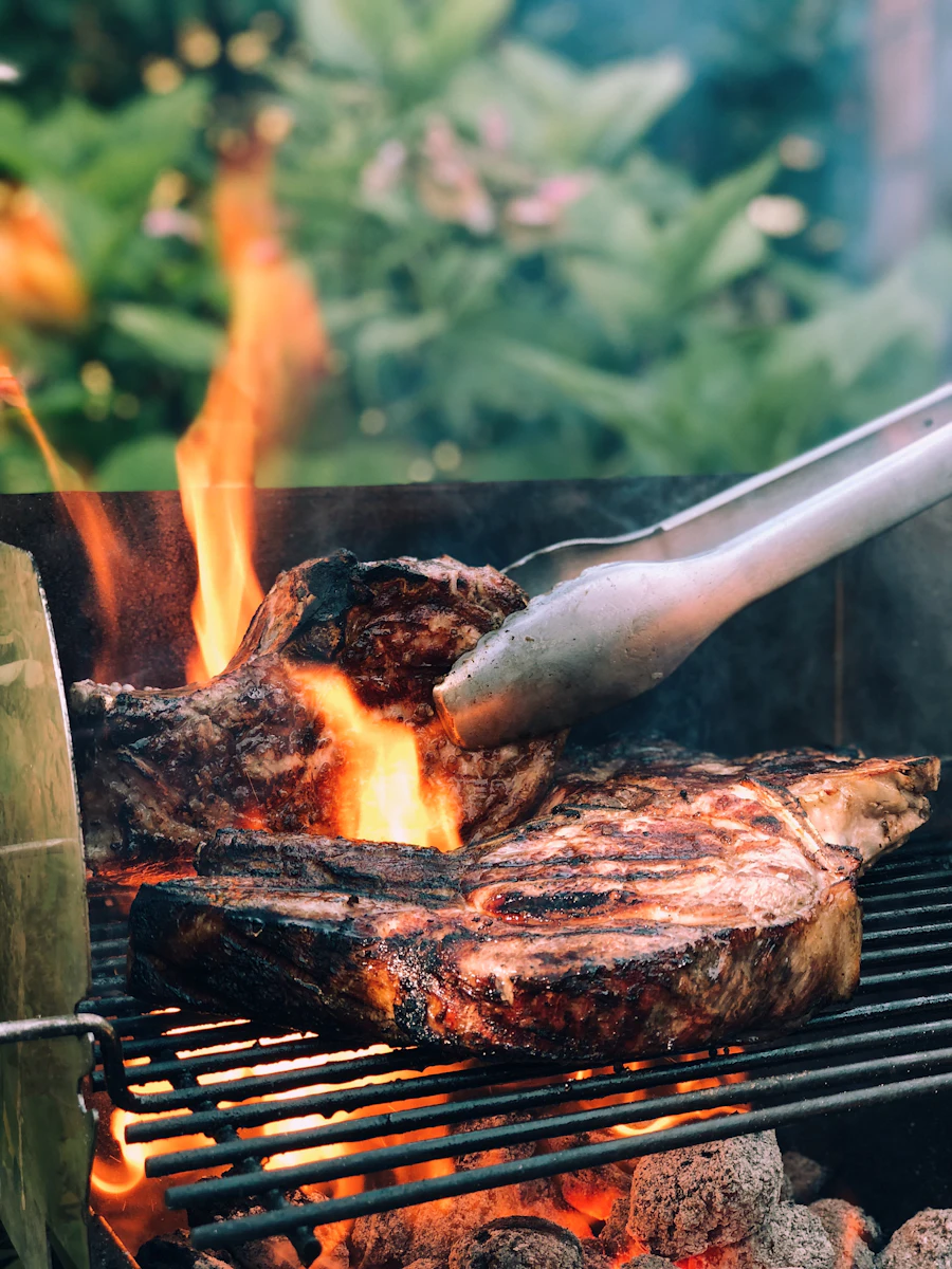 Meat cooking over an open charcoal grill