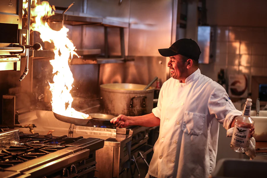 Chef cooking over a flame in a kitchen